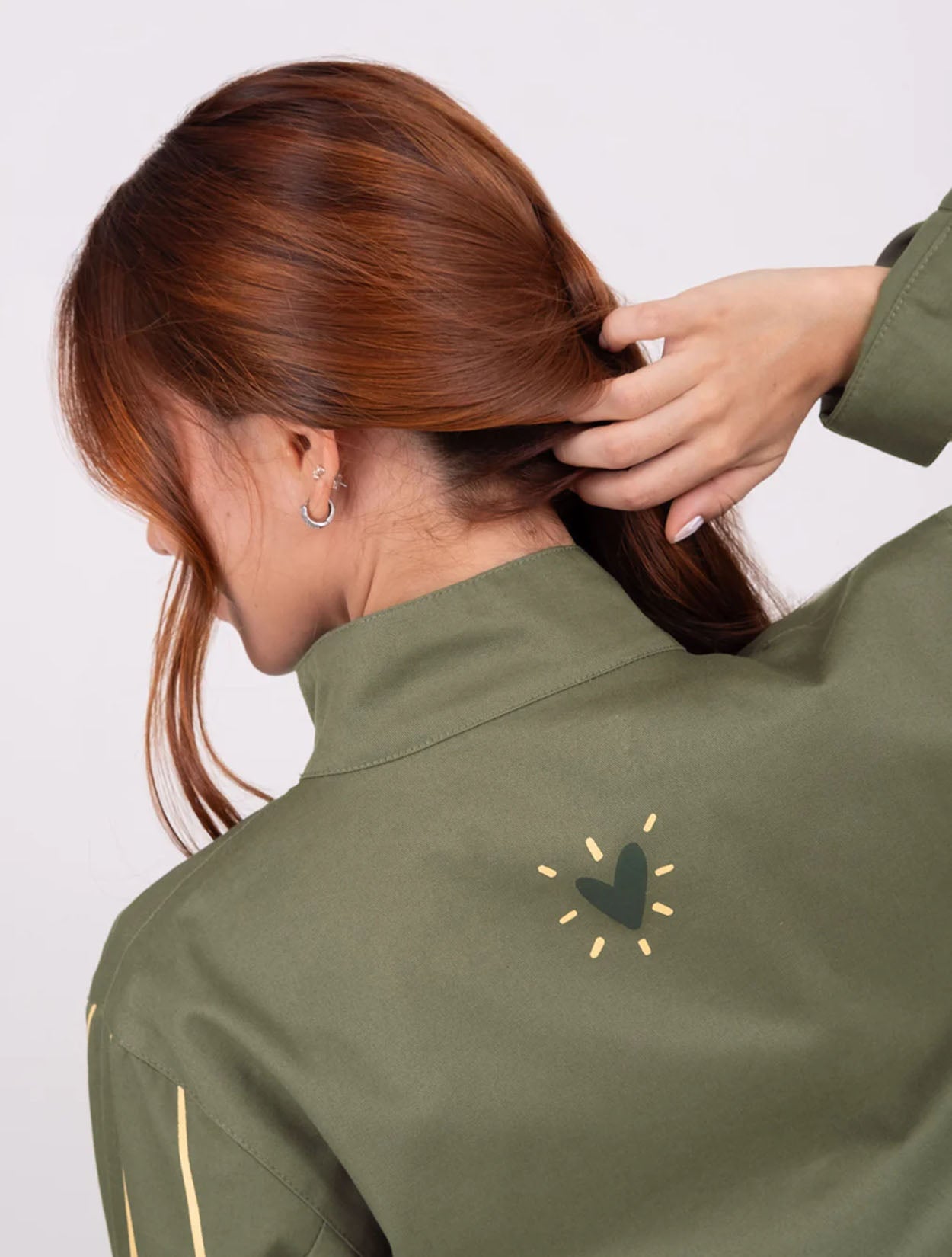 Chaqueta tipo parka verde militar con bordado Fuego para mujer – Juliana Sanchez | Casa Precis, Concept Store. Segundo plano.