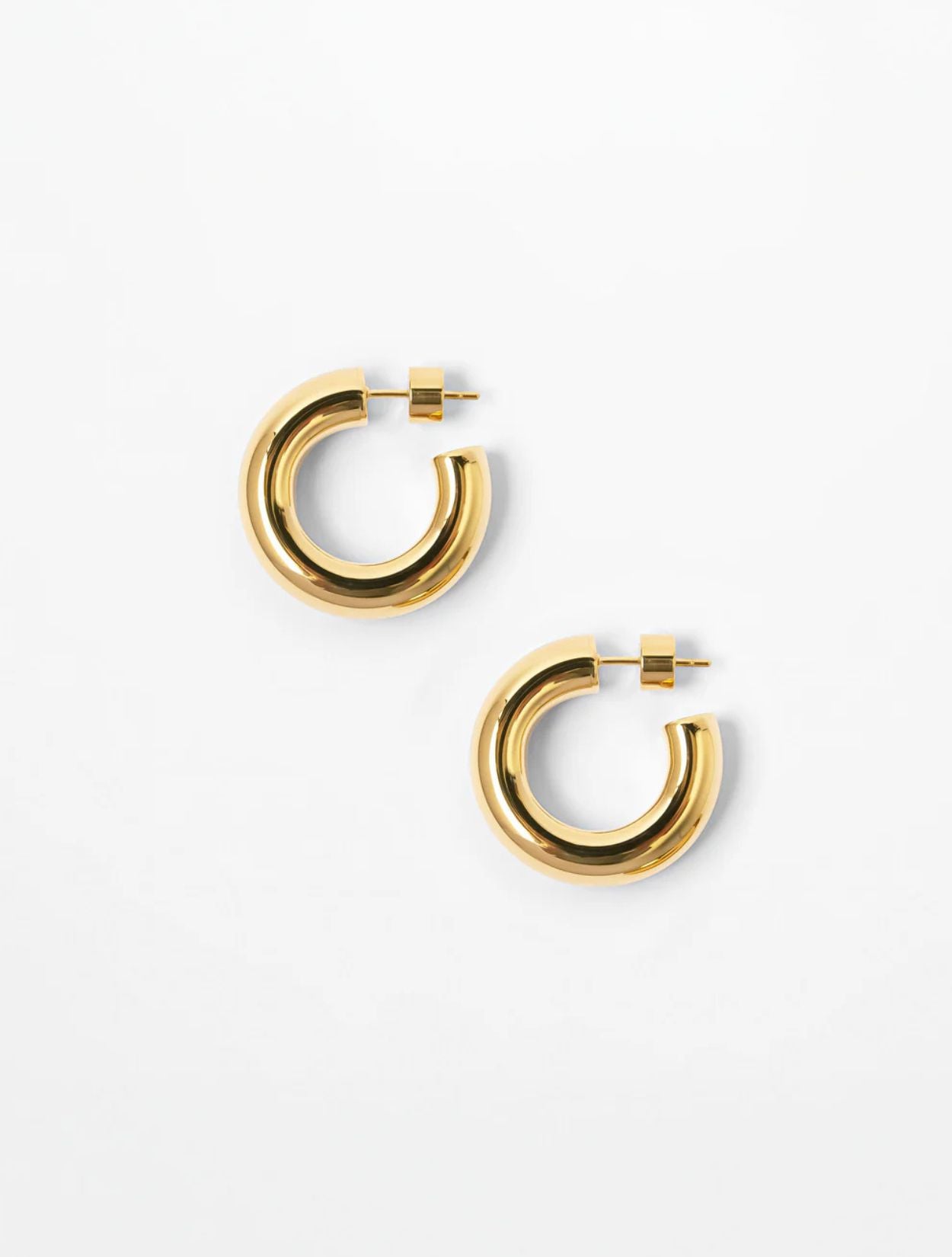 Aretes tipo candonga Fixi Hoops dorados con baño de oro y diseño arquitectónico para mujer – Sofía Llanos | Casa Precis, Concept Store. Primer plano.