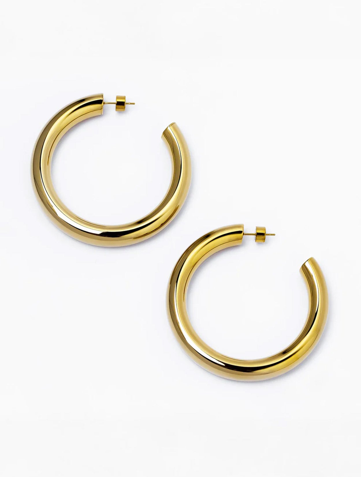 Aretes tipo candonga maxi Tera Hoops dorados con baño de oro y diseño de gota para mujer – Sofía Llanos | Casa Precis, Concept Store. Primer plano.
