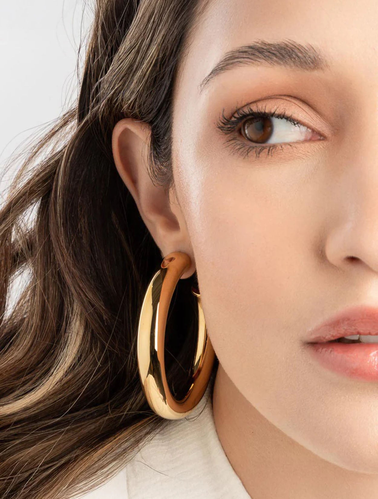 Aretes tipo candonga maxi Tera Hoops dorados con baño de oro y diseño de gota para mujer – Sofía Llanos | Casa Precis, Concept Store. Segundo plano.