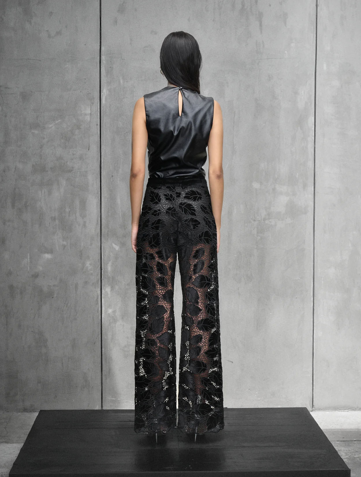 Top Noir Muse de Nord & Sud en color negro con detalle de lazos laterales y silueta estructurada – Moda colombiana de lujo | Casa Precis, Concept Store. Segundo plano.
